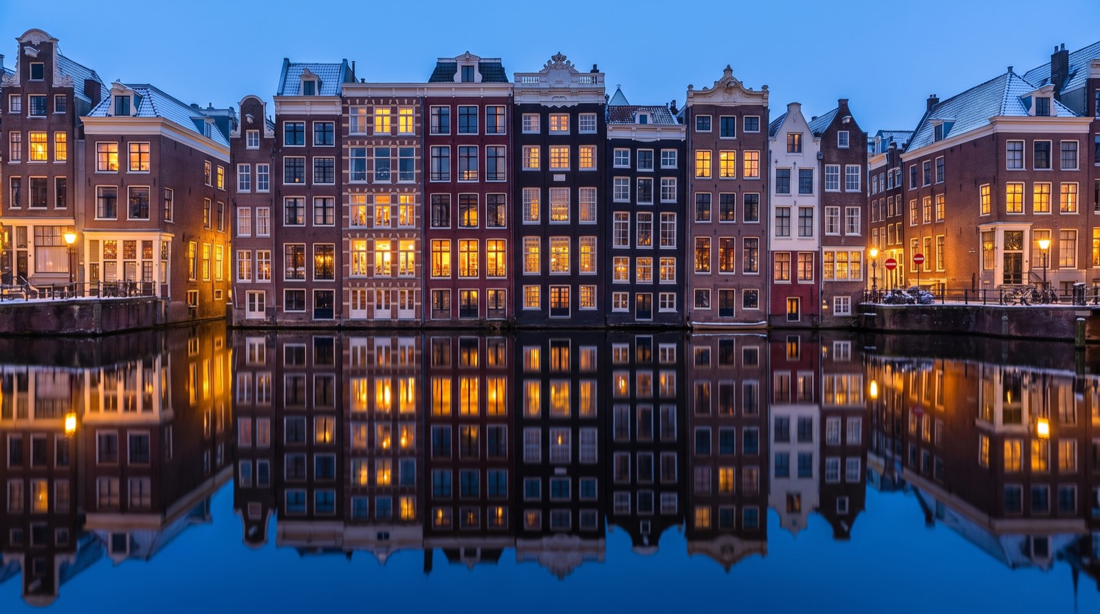 Grachtenpanden aan een Amsterdamse gracht bij avondlicht