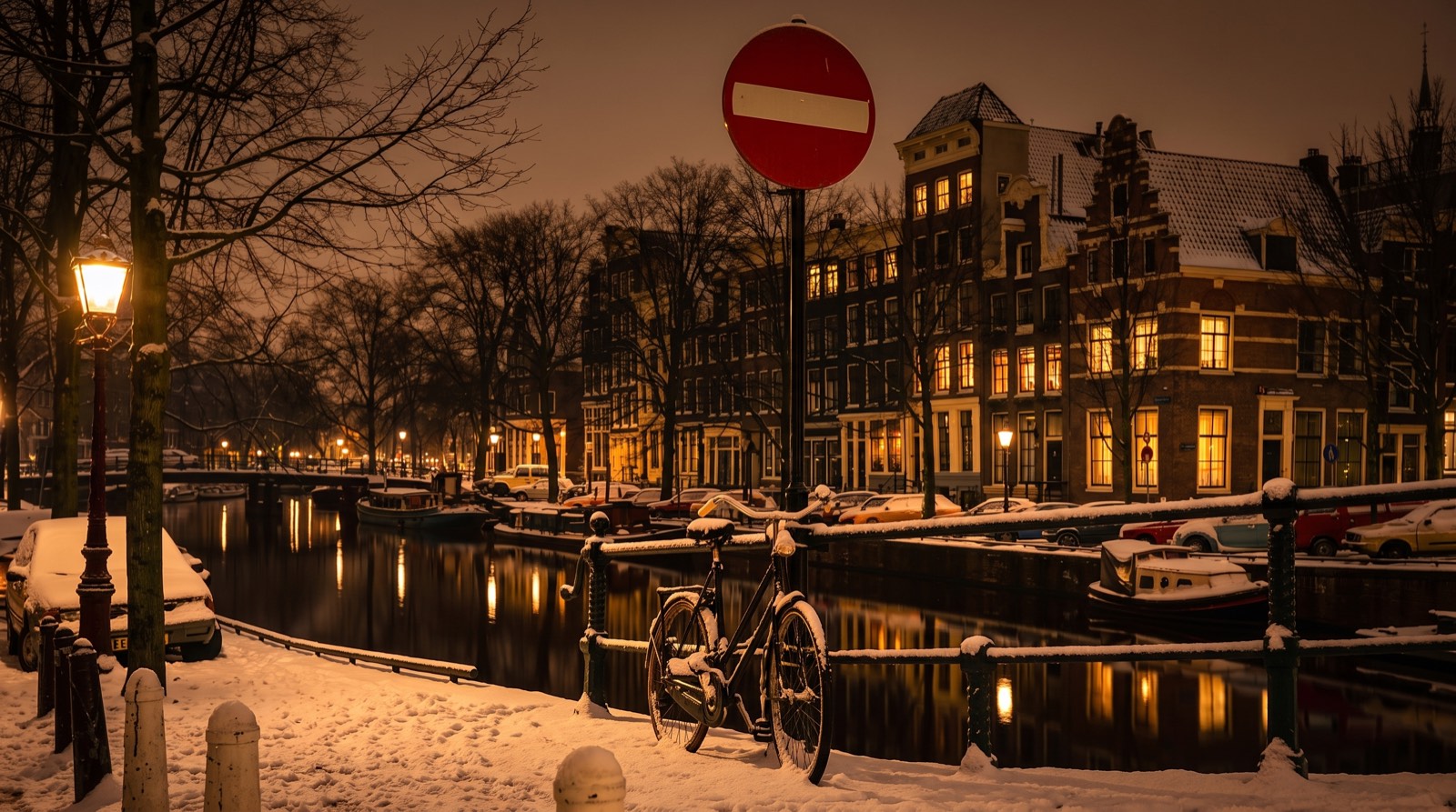 Uitzicht over een Amsterdamse gracht met bruggen en fietsen